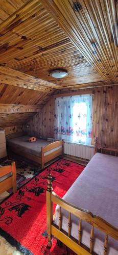 a bedroom with two beds in a room with a wooden ceiling at Sojka in Divčibare