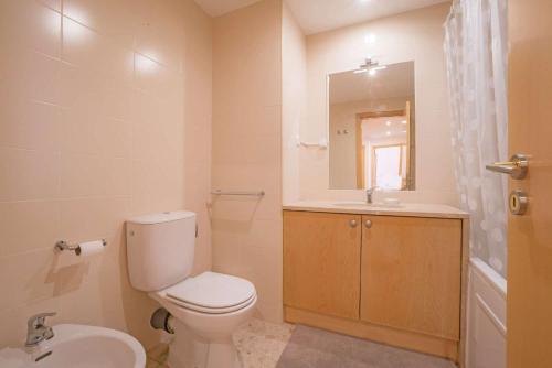 Un baño con inodoro, lavabo y espejo. en 1-minute walk to the Metro and 2 to the Supermarket, en Lisboa