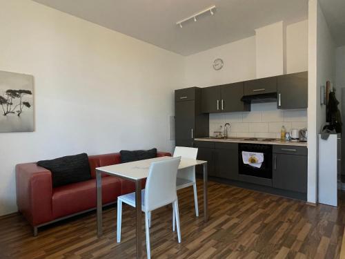Una sala de estar con una mesa y un sofá rojo. en Loft with balcony Enckekaserne, en Magdeburgo