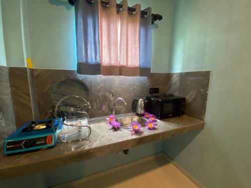 a kitchen counter with a toaster and flowers on it at The Shore Residence in Hikkaduwa
