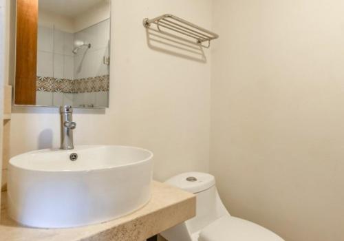 un bagno bianco con lavandino e WC di Hotel Meson de Sara a Querétaro