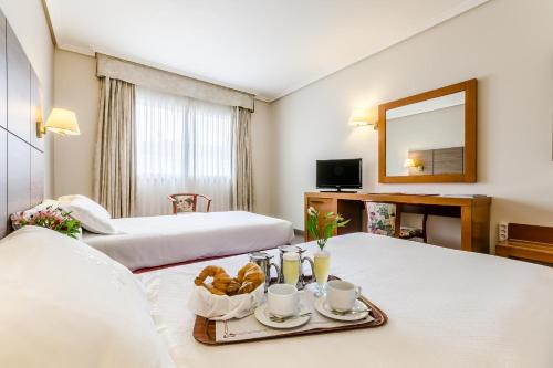 Habitación de hotel con 2 camas y bandeja de comida en Galicia Palace, en Pontevedra