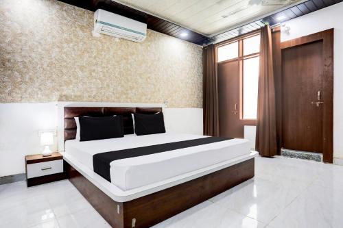 a bedroom with a large bed and a window at Hotel O Saraswati Resort in Kota
