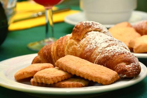 a plate with a croissant and cookies on a table at Albergo Martini in Chianciano Terme