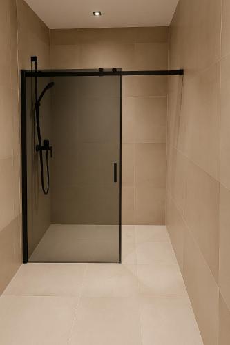 a shower stall with a glass door in a bathroom at Appartment Krimmler Bergtraum in Krimml