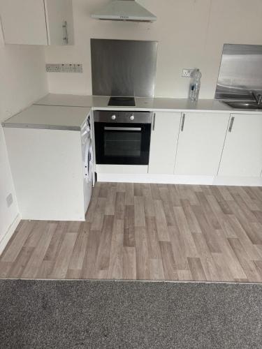 a kitchen with white cabinets and a stove at Manchester Guesthouse in Manchester