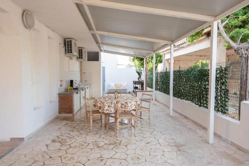una sala da pranzo con tavolo e sedie su un patio di Love mer- Granelli a Granelli