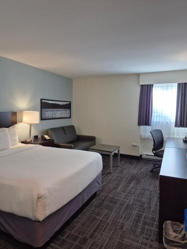 a hotel room with a bed and a desk and chair at Canad Inns Destination Centre Windsor Park in Winnipeg