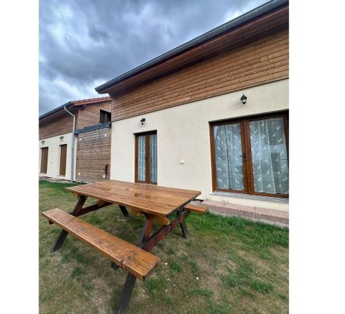 a wooden picnic table in front of a building at Gîtes pour 2 à 6 personnes Manala et Vivala in Metzeral