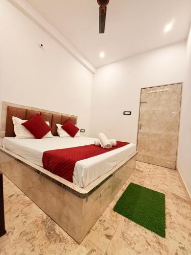 a bedroom with a large bed with red pillows at LA VACA Casa in Varanasi