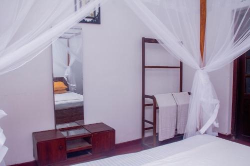 une chambre avec un lit superposé et un miroir dans l'établissement Red Araliya Villa Weligama, à Weligama