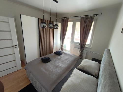 a bedroom with a bed and a couch at APARTMÁN - 3 izbový byt in Veľký Krtíš