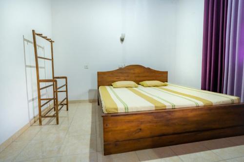 希克杜沃The Quiet House - Hikkaduwa的一间卧室设有一张木床和梯子