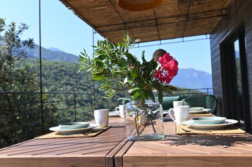 a wooden table with a vase of flowers on it at Casa Paula in Serriera