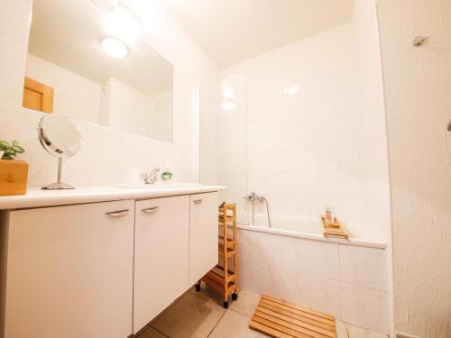 een badkamer met een wastafel, een bad en een spiegel bij Castelgolf in Vesin