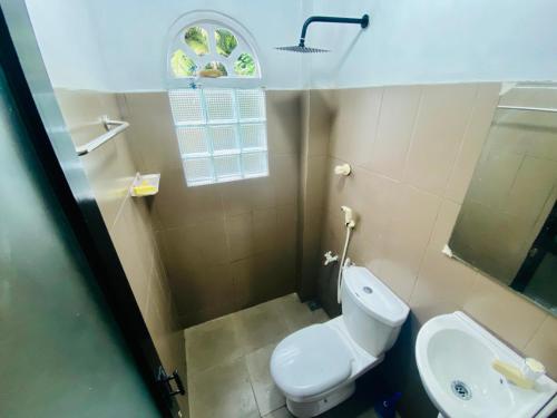 Un baño con un inodoro blanco y un lavabo. en Rest and Recharge homestay airport transit katunayaka, en Minuwangoda