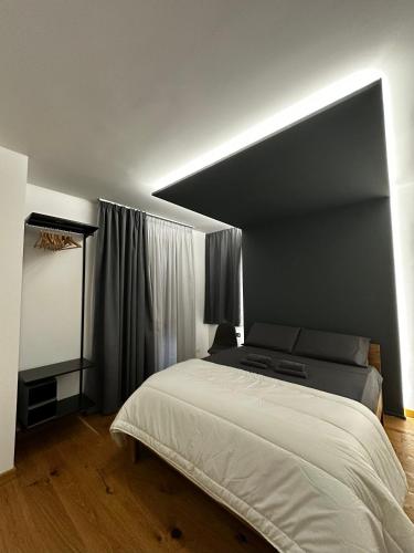 a bedroom with a large white bed in a room at Villa NEONERO in Nicolosi