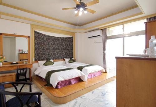 a bedroom with two beds and a desk and a mirror at 陶陶居商旅 Tautauchu Hotel in Hualien City