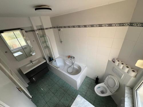 a bathroom with a tub and a toilet and a sink at Heusenstamm Home & Work in Heusenstamm