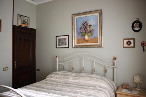 a bedroom with a bed and a painting on the wall at La Casa di Famiglia tra Siena, Chianti e Crete in Castelnuovo Berardenga