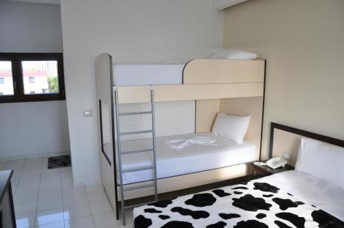 a bedroom with a bunk bed and a cow print rug at Sunrise Hotel Cameria in Durrës