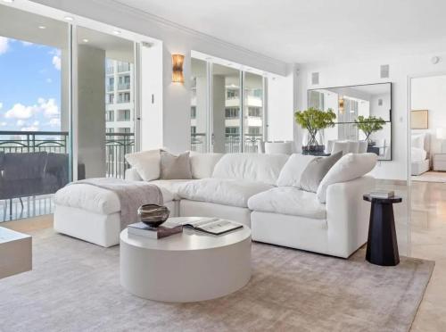 a white living room with a white couch and a table at Coconut Grove Elegance Five Star Condo Living in Miami