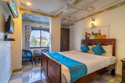 a bedroom with a large bed with blue sheets at Storica Stays Panorama Haveli Udaipur in Udaipur