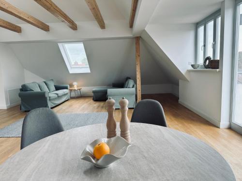 a table with an orange in a bowl on it at Dr. Bockemüller Appartements in Sickte