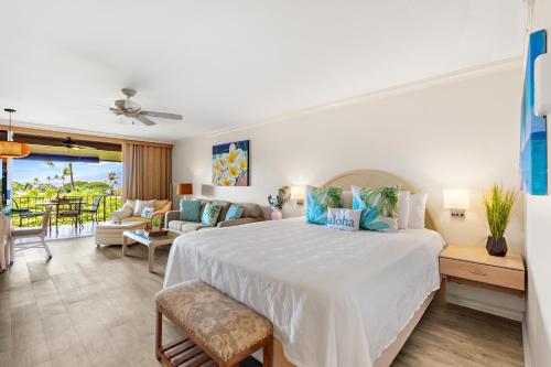 a bedroom with a large bed and a living room at Maui Eldorado Condo K207 in Kaanapali