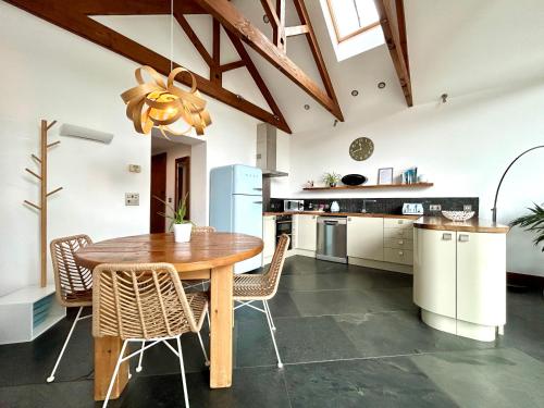 马根波思Merlin Farm Cottages short walk to Mawgan Porth Beach and central location in Cornwall的配有木桌和椅子的厨房