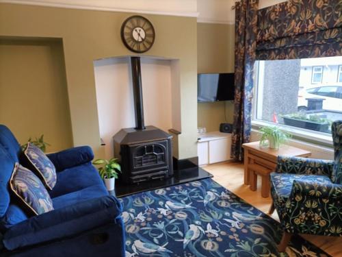 - un salon avec un canapé bleu et une cuisinière dans l'établissement Mill cottage, à Carrickfergus