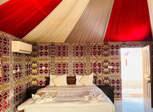 a bedroom with a bed with a red ceiling at Lunar Mirage Camp in Wadi Rum