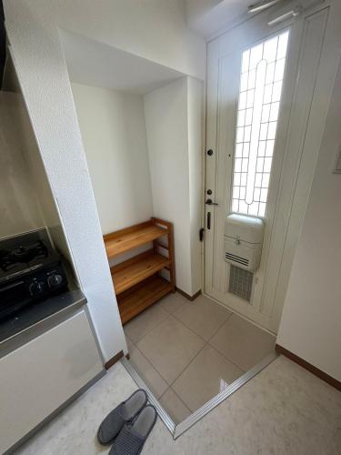 a small room with a door and a window at Arusa-Ishite 2F in Matsuyama