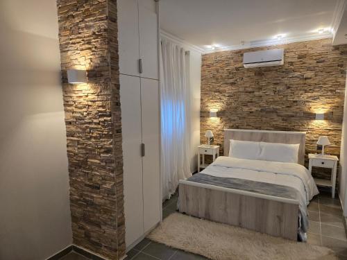 a bedroom with a brick wall and a bed at White House in Tríkala