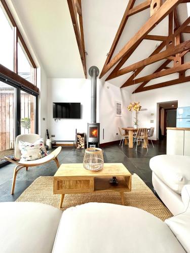 a living room with white furniture and a fireplace at Merlin Farm Cottages short walk to Mawgan Porth Beach and central location in Cornwall in Mawgan Porth