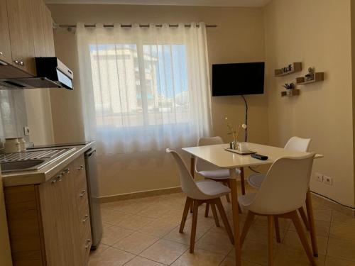 una cocina con mesa y sillas y una ventana en ApartHotel Sea & Back view studios, en Durrës