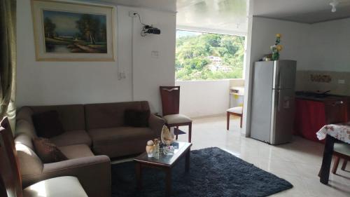 a living room with a couch and a refrigerator at DESTINY Apto Central in San Rafael