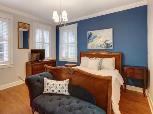 Dormitorio azul con cama y sofá en Liberty Street Retreat, en Savannah