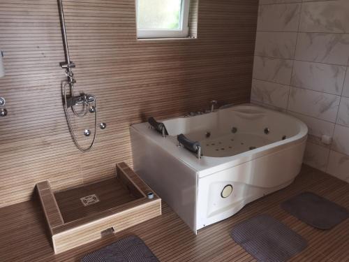 a bathroom with a large tub and a shower at Domaćinstvo Šeširče in Rudnik Kačerski