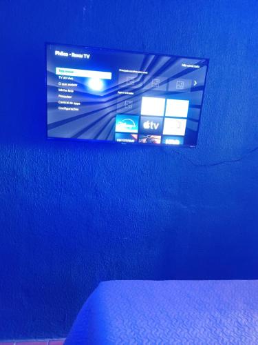a blue wall with a tv on top of a bed at Casa Catarina in São Roque