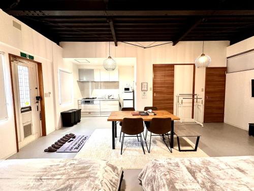 ein Zimmer mit Tisch und Stühlen und eine Küche in der Unterkunft Arusa-Ishite 1F in Matsuyama