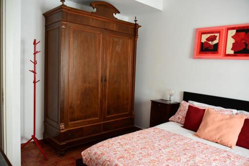 a bedroom with a wooden cabinet next to a bed at The window to the sea - a stone's throw from the beach in Genova