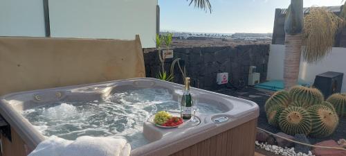 - un bain à remous avec une bouteille de champagne et un bol de fruits dans l'établissement Villa Emma Playa Blanca, à Playa Blanca