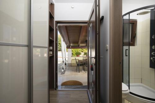 a bathroom with a glass door leading to a patio at Captain Villa 2 km to the beach in Vintijan
