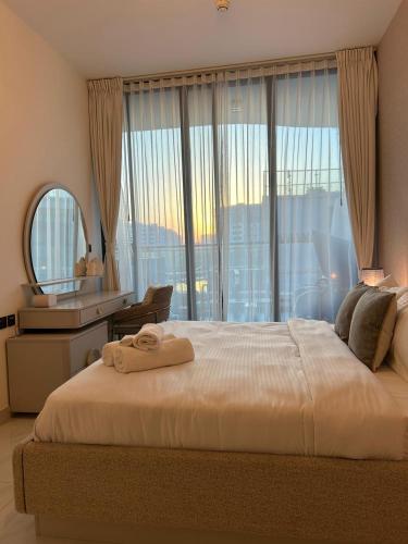 a bedroom with a large bed with a large window at Private Pool Stylish 1BR Arjan in Dubai