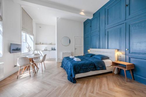 a bedroom with blue walls and a bed and a table at B&B Cleyn Cruysenborgh 1531 in Dordrecht