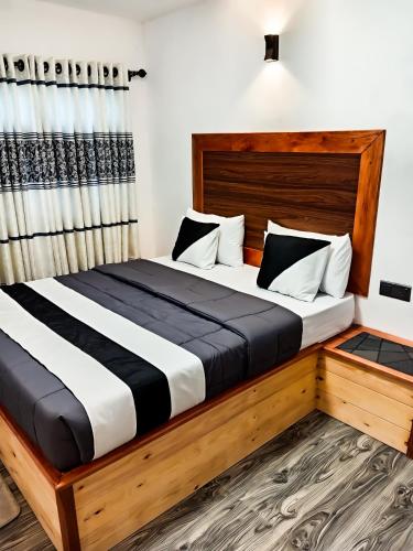 a bedroom with a large bed with a wooden headboard at Evergreen Resort Ella in Ella