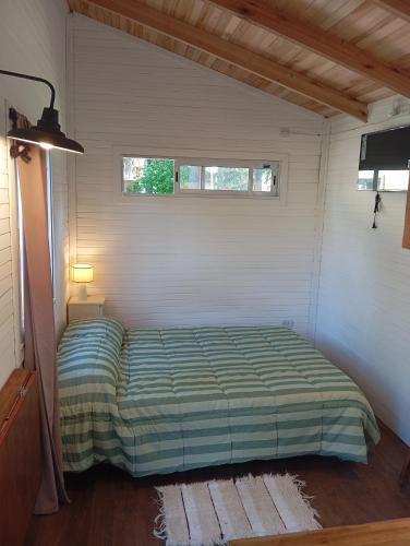 a small bedroom with a bed in a room at Cabañas Del Lolo in Villa Ventana