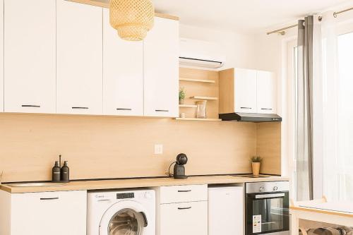a kitchen with white cabinets and a washing machine at Panorama Sunset Studio in Stara Zagora