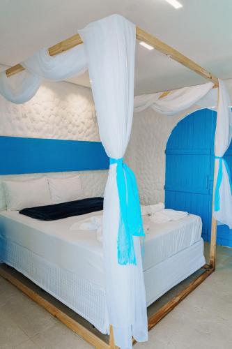 two bunk beds with blue and white curtains in a room at KEFI POUSADA in Maragogi